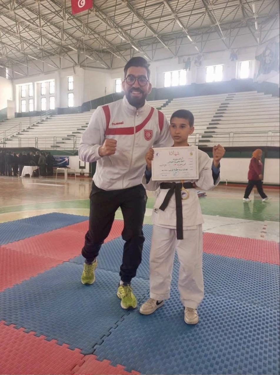 Un jeune karatéka ceinture noire avec son diplôme