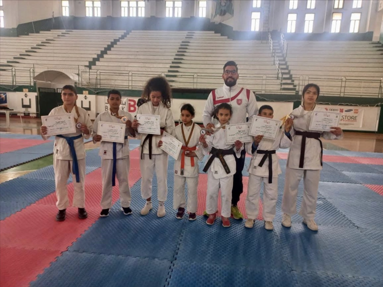 Les karatékas du club posent avec leurs diplômes et leur coach